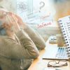 Туман в голове при менопаузе: женщина 45+ за ноутбуком пытается сосредоточиться и планирует шаги, чтобы вернуть ясность